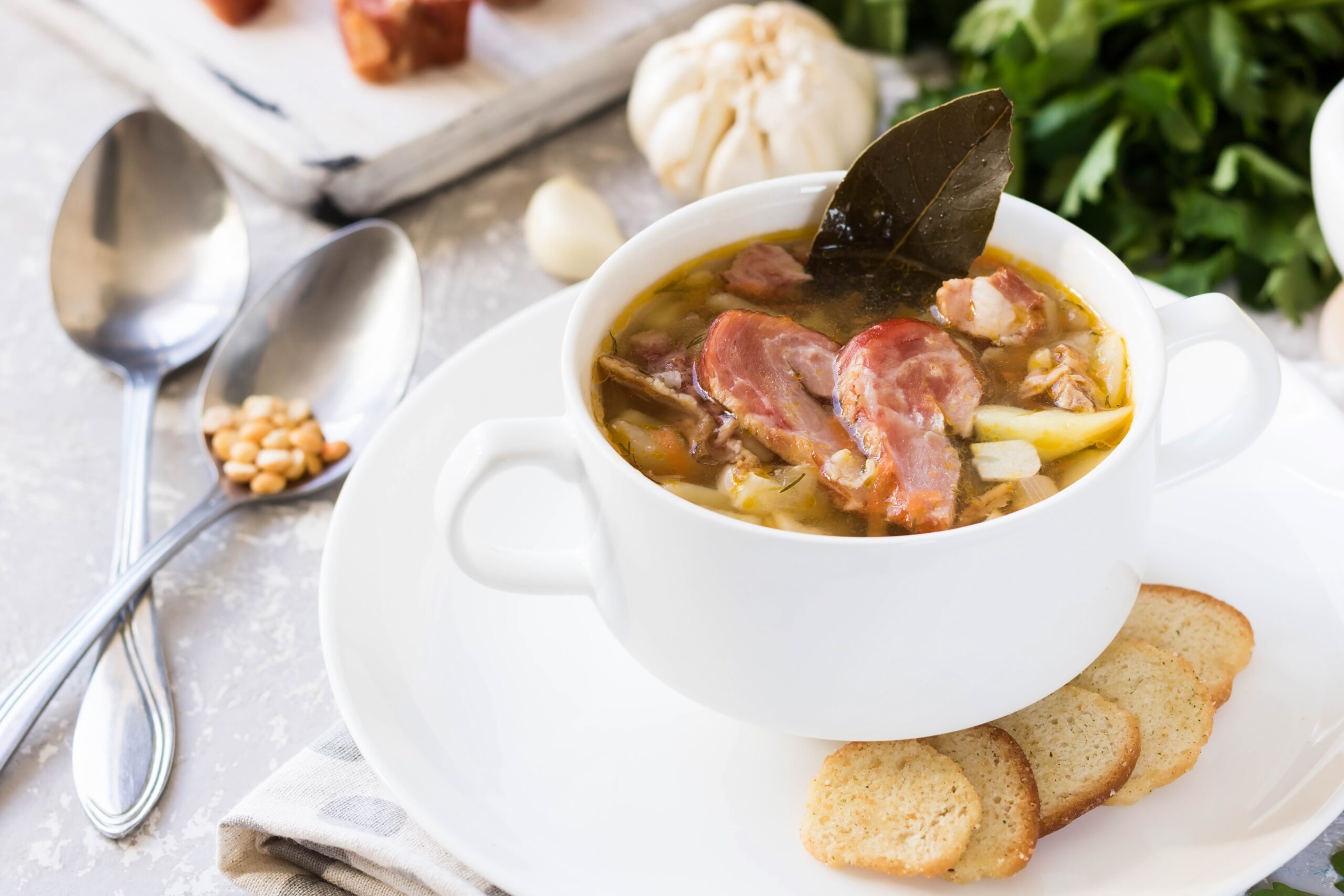 Ham Bone and Split Pea Soup served in a white bowl with small pieces of bread