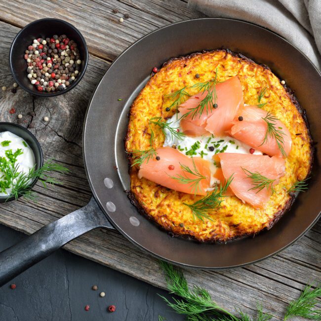 Potato Pancakes with Cream Cheese and Smoked Salmon served in a cast iron pan